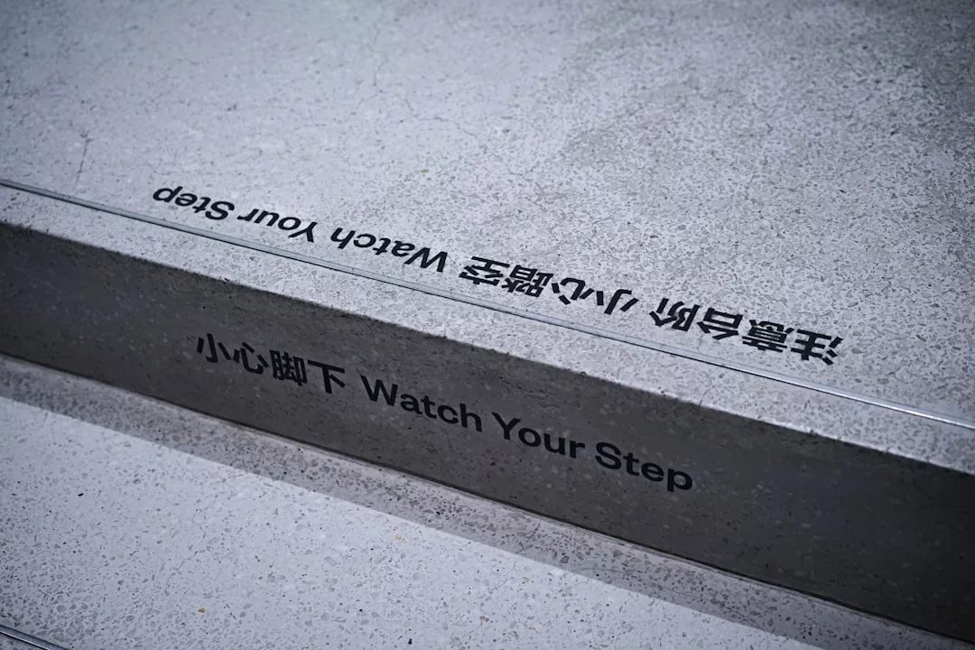 Eine GLAMESiA-Betonstufe mit der Aufschrift "Watch Your Step" in englischer und chinesischer Sprache sowohl auf der vertikalen als auch auf der horizontalen Fläche.