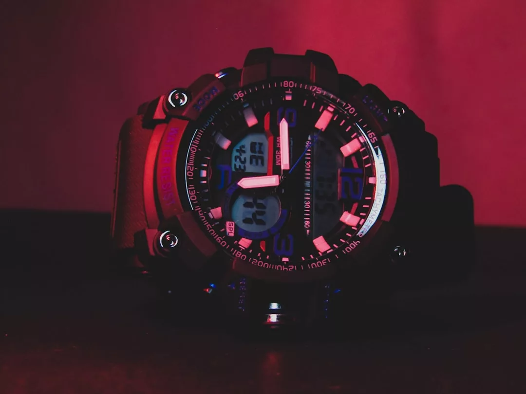 Eine Nahaufnahme einer digitalen und analogen GLAMESiA-Armbanduhr mit robustem Design, die von roter und blauer Beleuchtung beleuchtet wird und die Uhrzeit von 3:22 anzeigt.