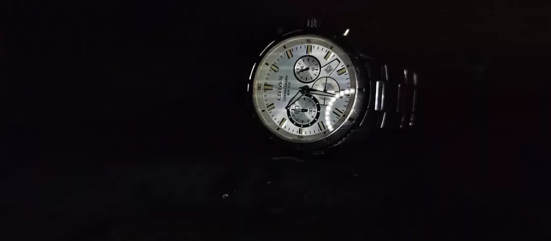 Eine silberne GLAMESiA-Armbanduhr mit weißem Zifferblatt, römischen Ziffern und drei Hilfszifferblättern wird vor einem schwarzen Hintergrund angezeigt.