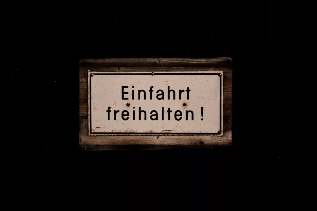 Ein rechteckiges GLAMESiA-Schild mit dem deutschen Text "Einfahrt freihalten!" auf dunklem Hintergrund mit der Aufforderung, die Einfahrt freizuhalten.