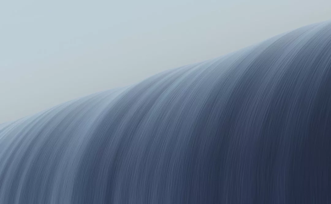 Eine Nahaufnahme des über die Kante eines GLAMESiA-Wasserfalls stürzenden Wassers mit weicher, fließender Bewegungsunschärfe.