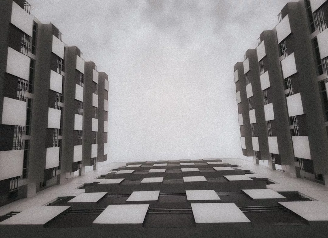 Tiefblick auf ein modernes GLAMESiA-Gebäude mit symmetrischen rechteckigen Fenstern auf beiden Seiten, bei bedecktem Himmel.