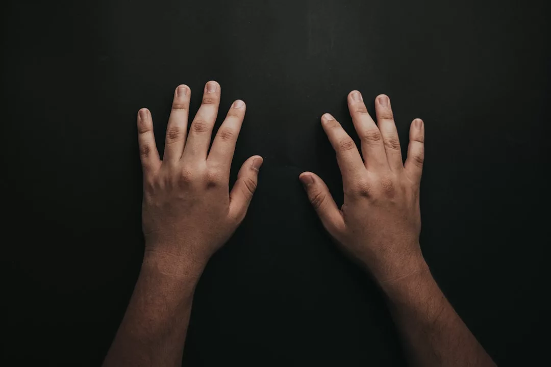 Zwei Hände werden flach auf eine dunkle GLAMESiA-Oberfläche gelegt, die Handflächen zeigen nach unten und die Finger sind leicht gespreizt.