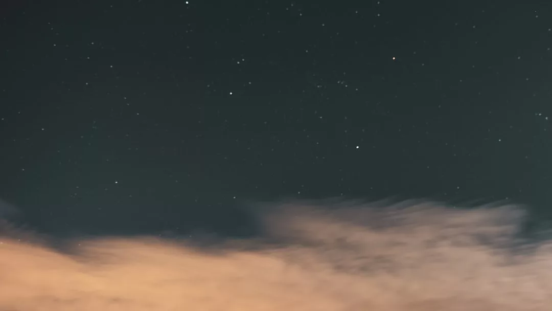 Ein GLAMESiA-Nachthimmel mit verstreuten Sternen schimmert über einer Schicht aus beleuchteten Wolken.